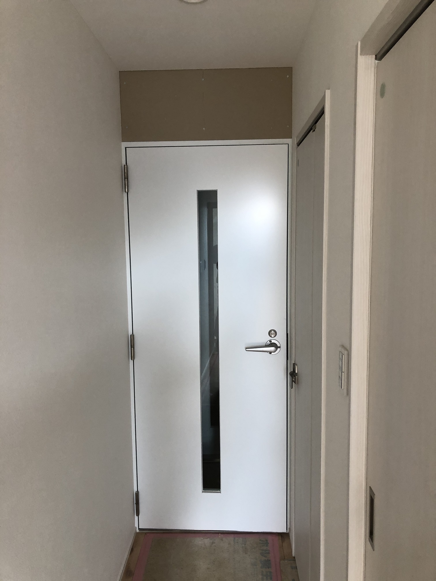 玄関から真っすぐの場所にKOTOBUKI製防音ドアで壁のクロスが白なので防音ドアも白にしてます。
